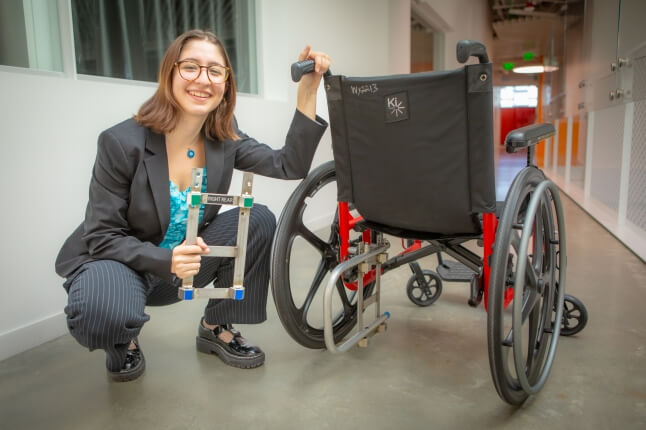 Harvard SEAS senior Zeynep Bromberg kneeling next to a manual wheelchair