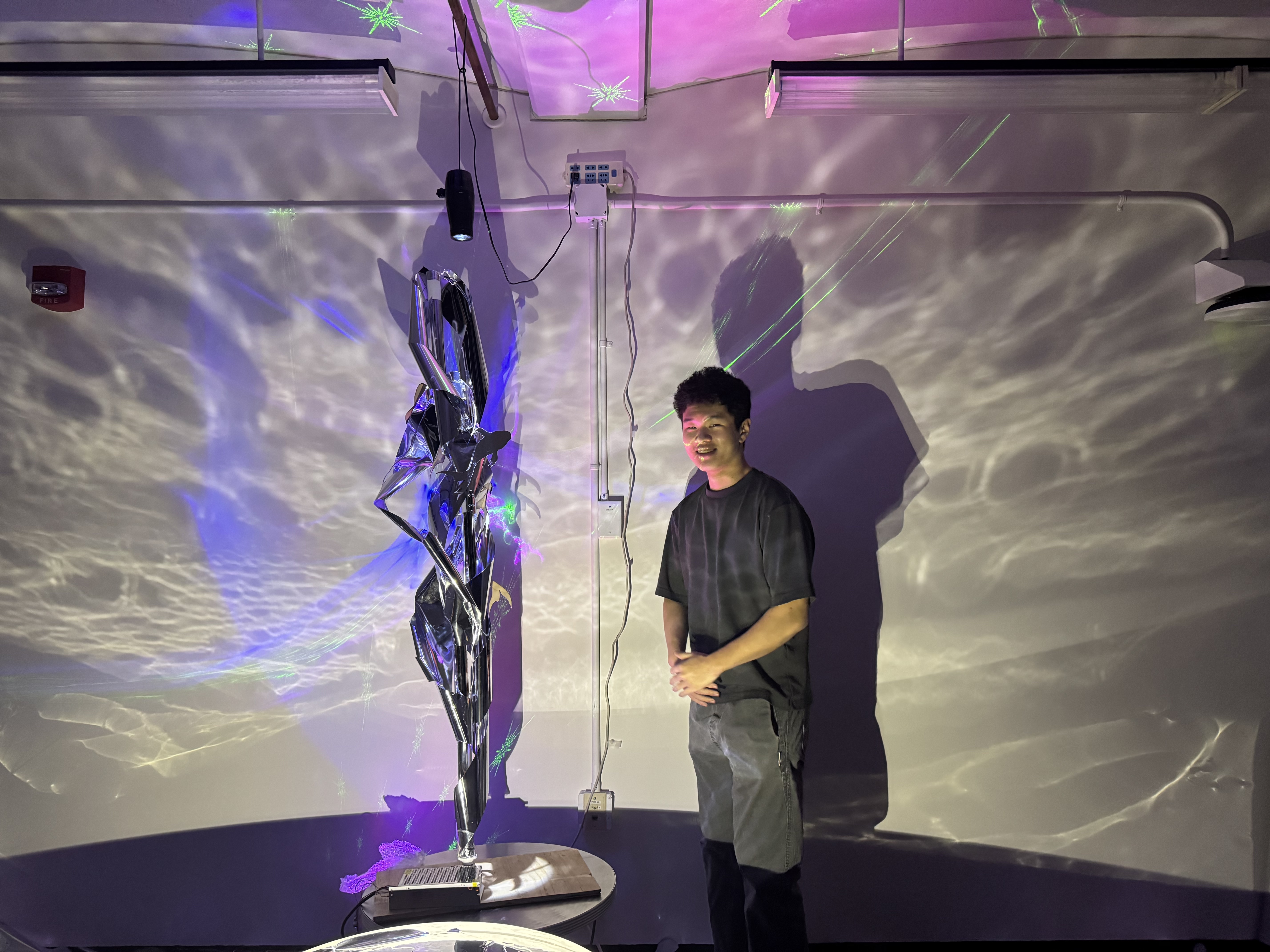 University of Virginia student Roger Zhu next to a reflective statue