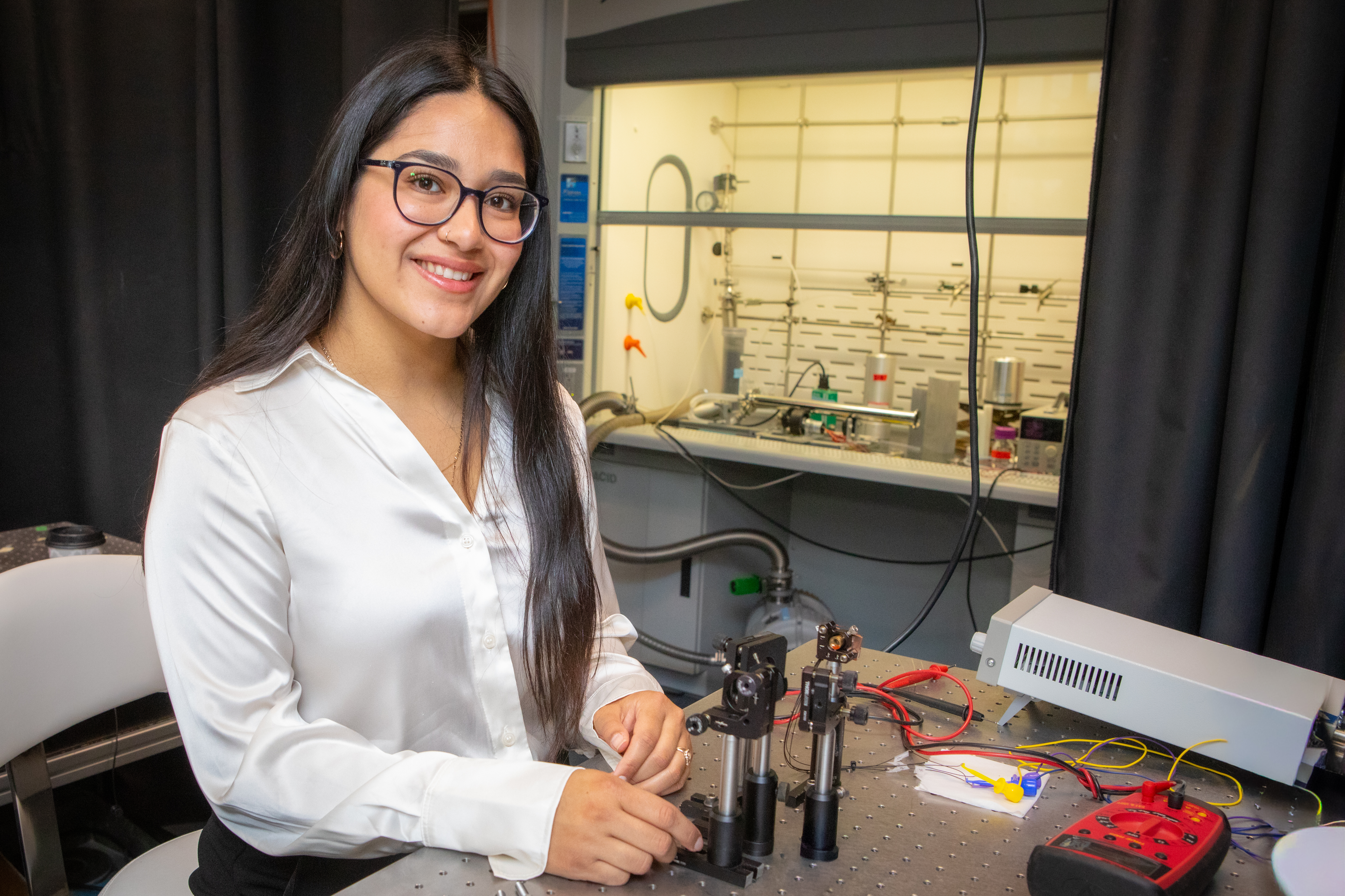 Harvard SEAS student Lizbeth Ibarra next to lab equipment