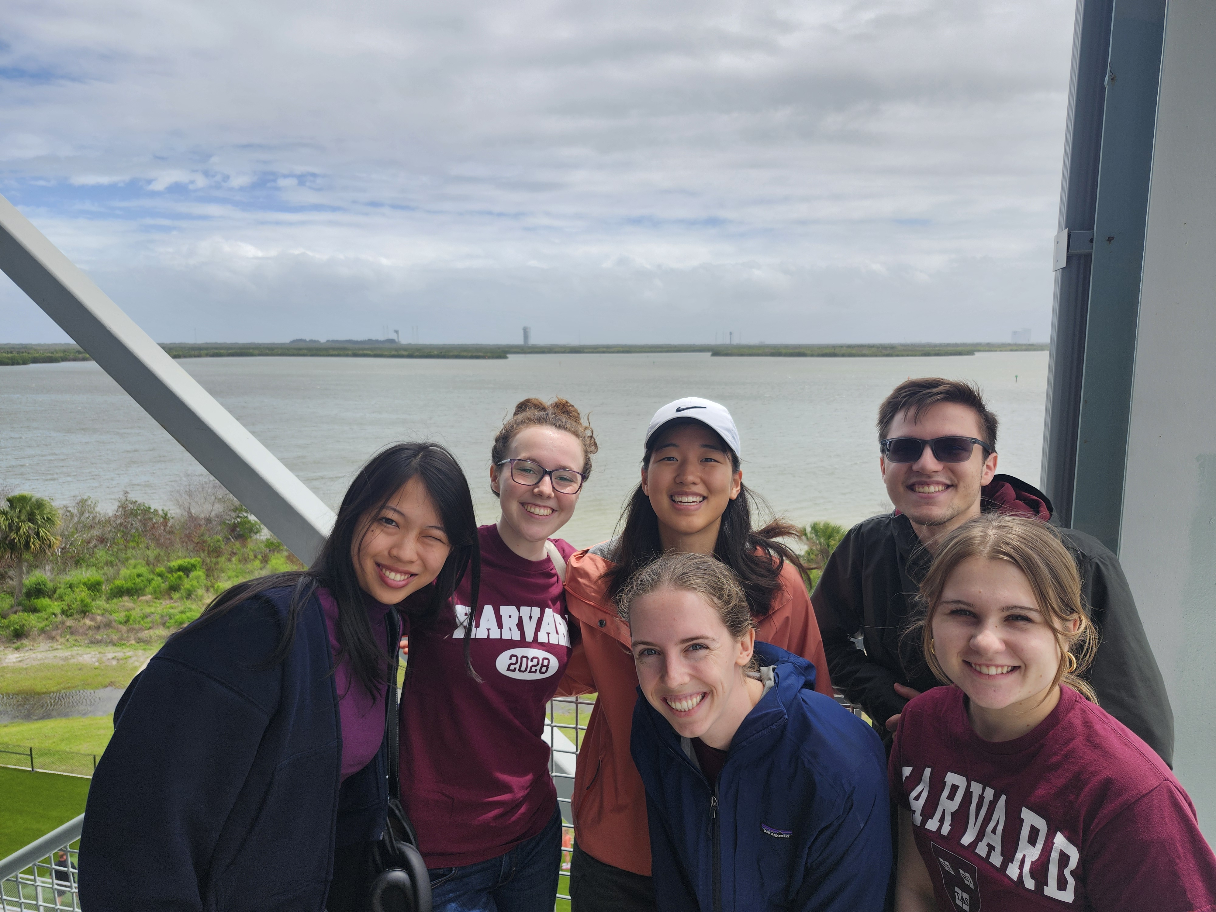Harvard SEAS students with a launch pad in the background in Florida