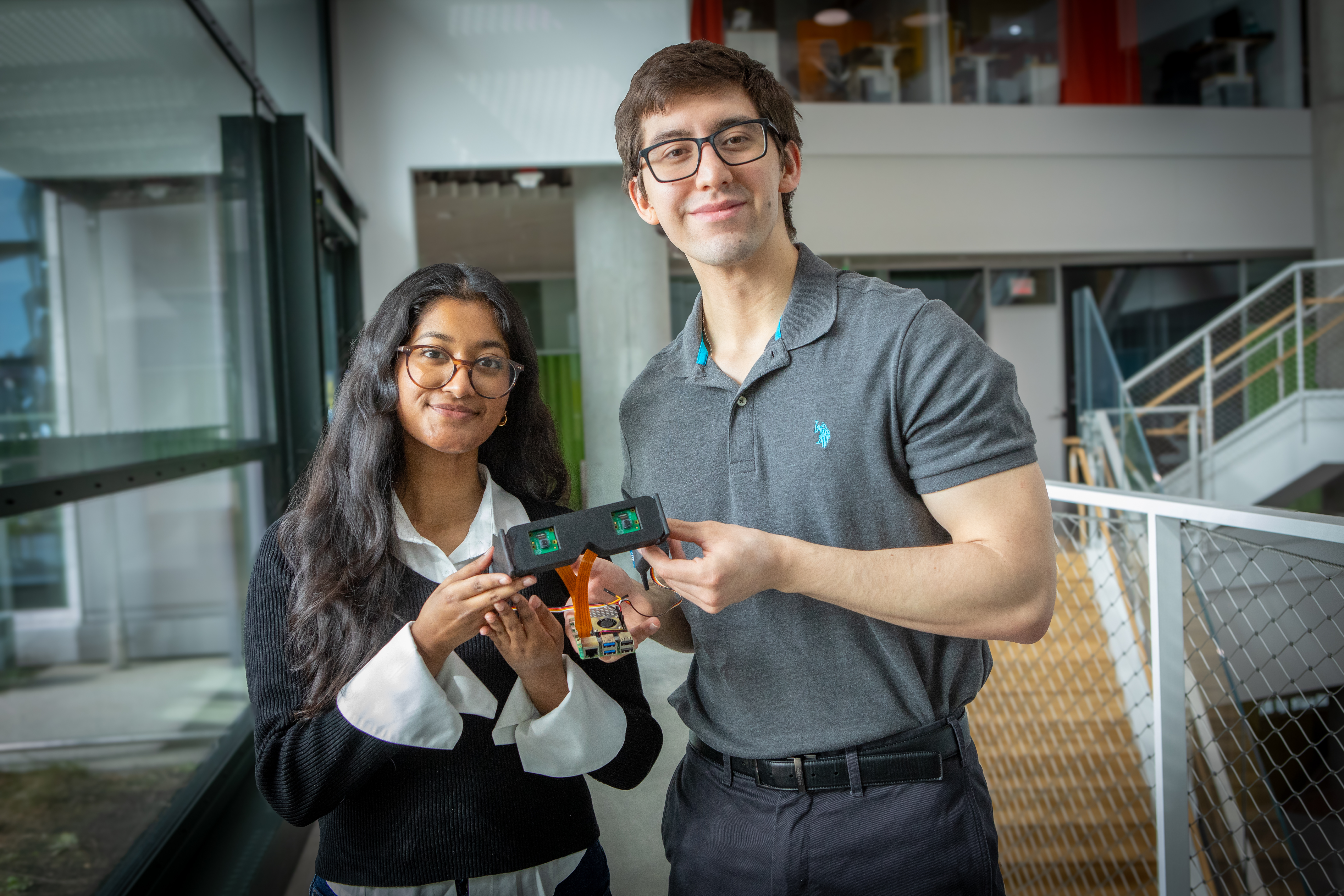 Harvard SEAS students Elsa Oreen and Daniel Kocot holding a pair of smart glasses