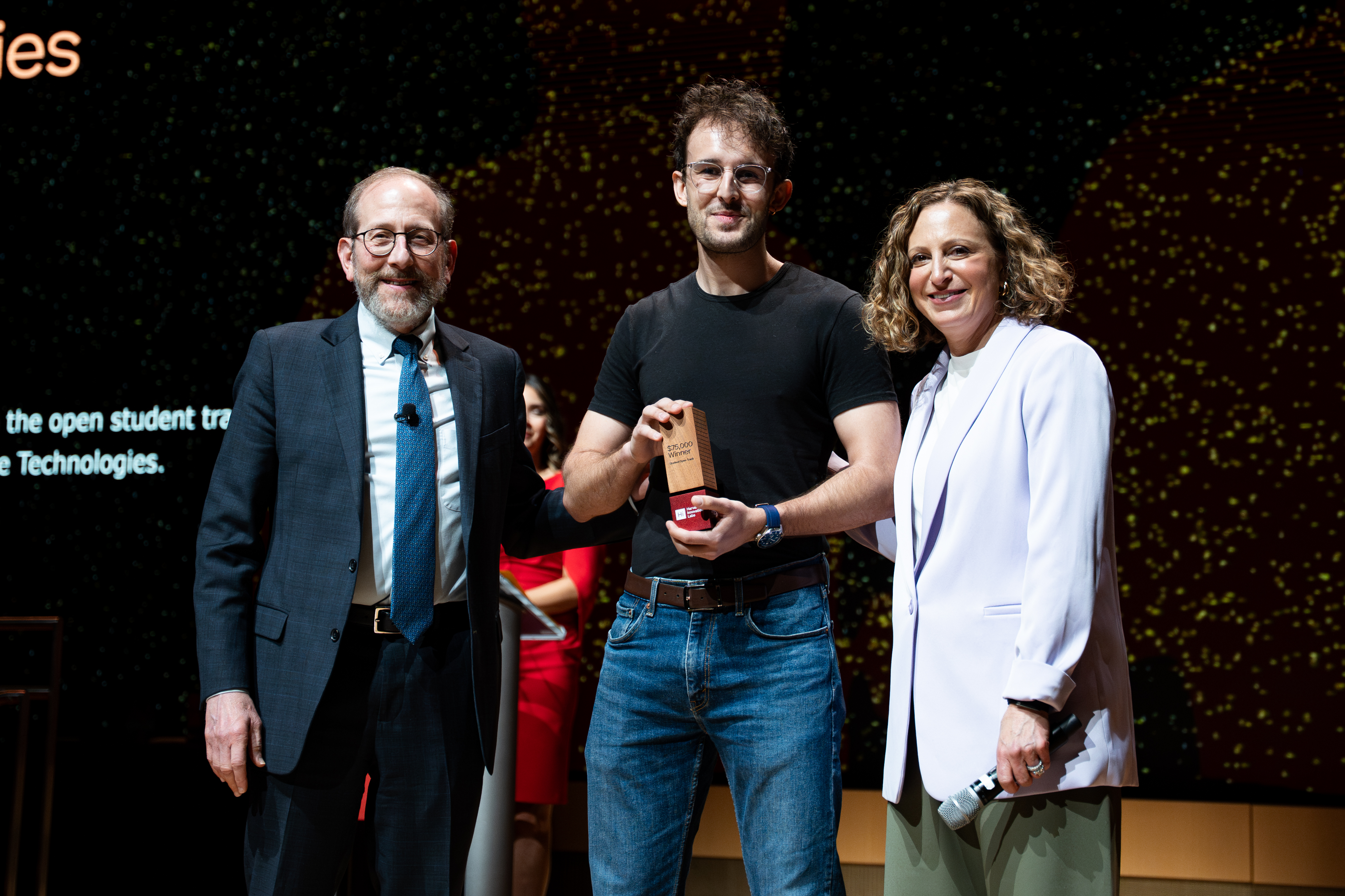 Harvard SEAS student Yann Calvó López on a stage with Harvard President Alan M. Garber and Harvard Innovation Labs Executive Director Jill Kravetz