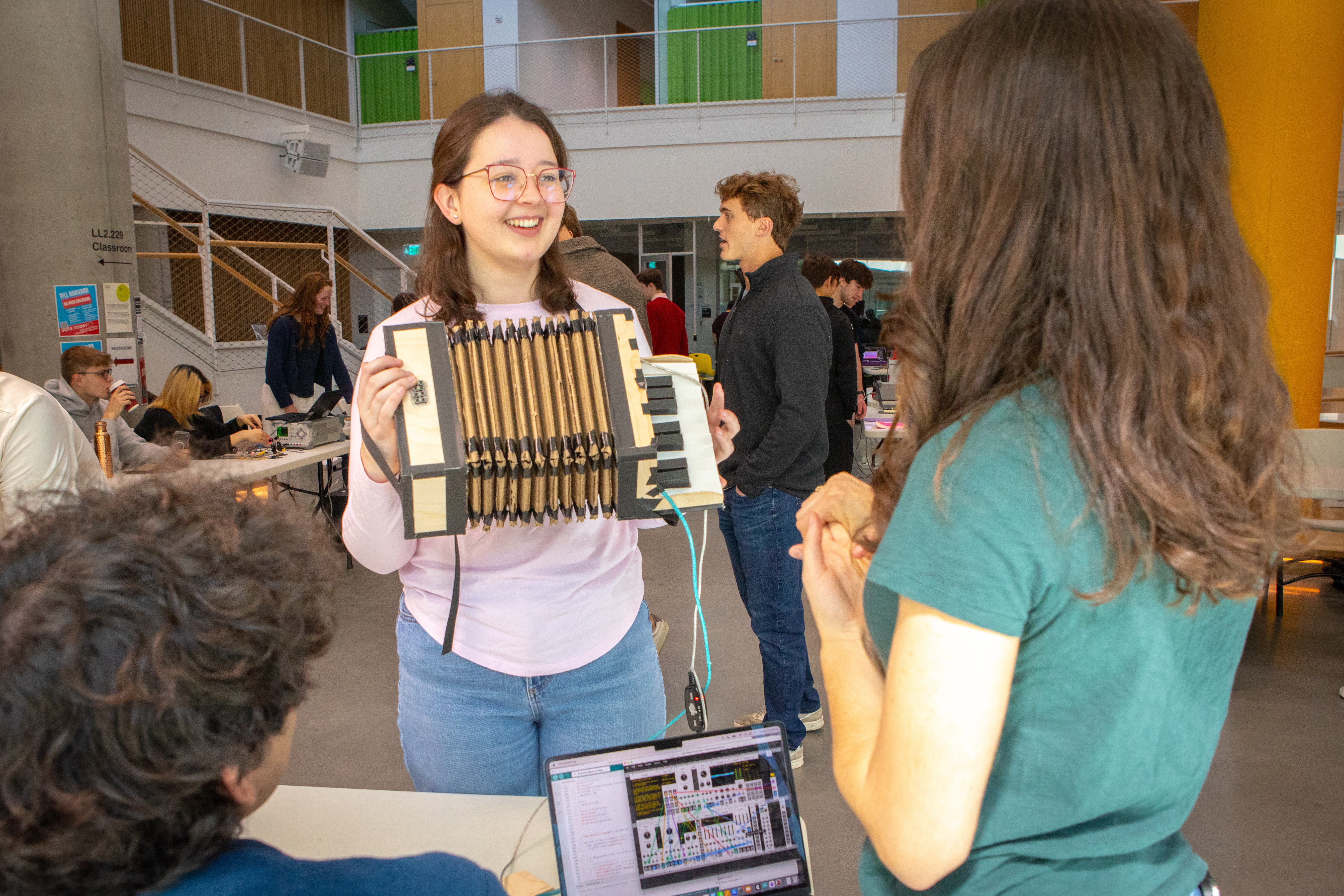 A Harvard student holding an accordion made out of cardboard