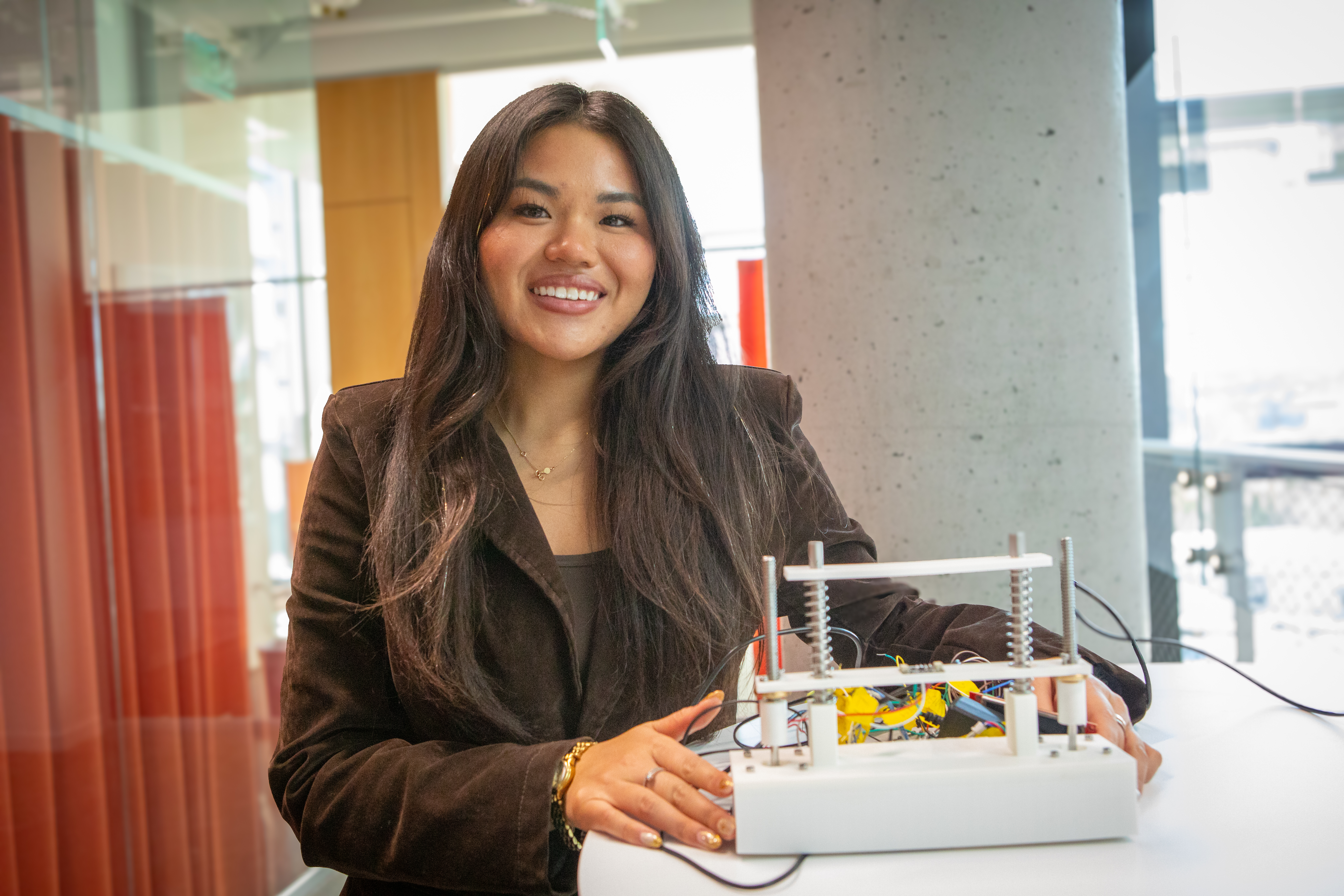 Harvard SEAS student Katie Le holding a small electronic device
