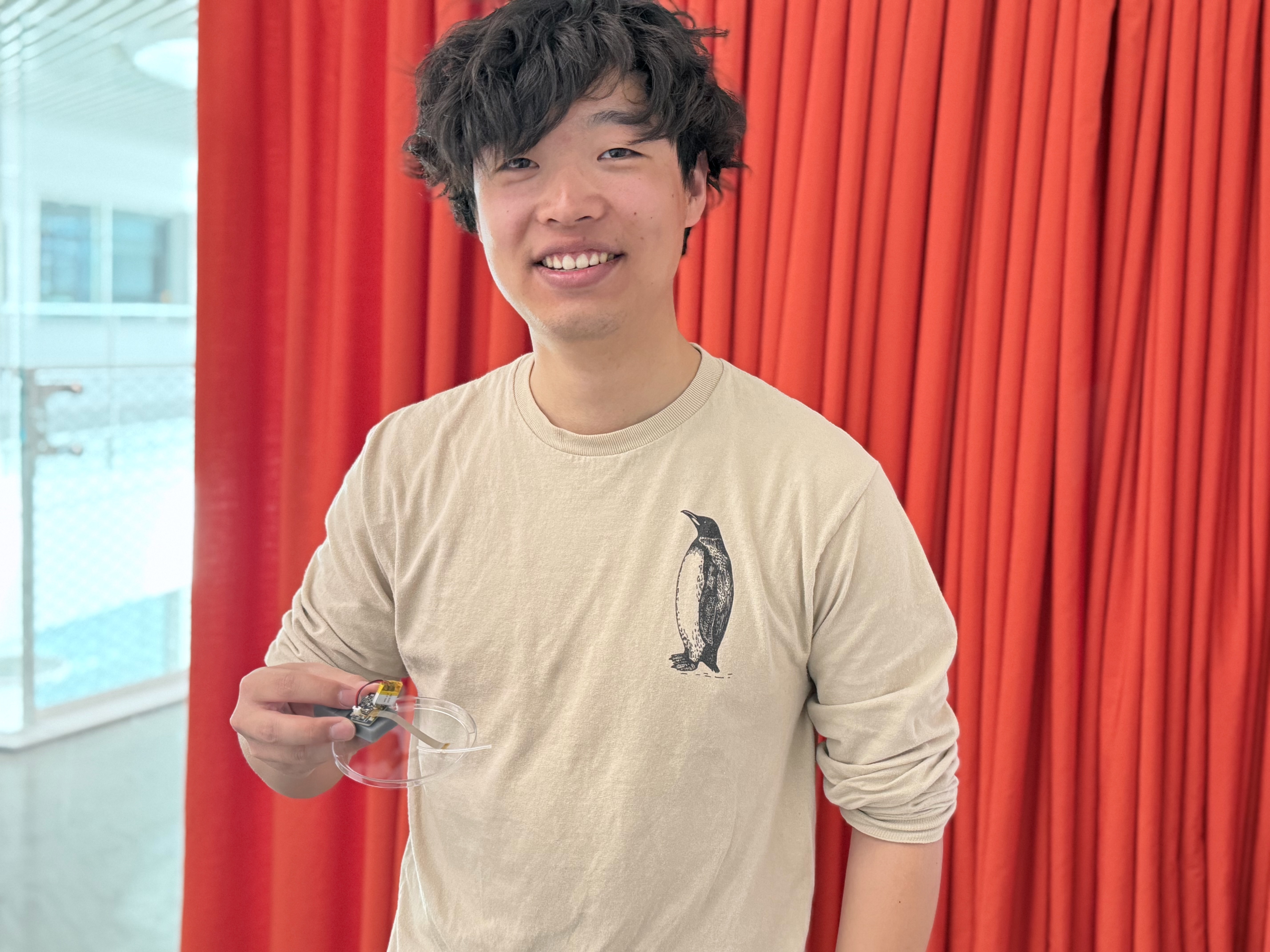 Harvard SEAS student Jerry Li holding a small electronic device