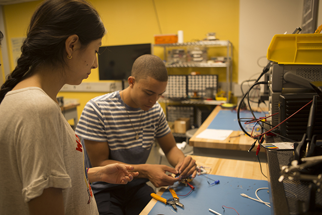 Mechanical engineering concentrator Bryant Huggins, S.B. ’19 (right) and UTEC student Anarea Alvarez Veva collaborate to test the circuits for the team’s microfluidic device. (Photo by Adam Zewe/SEAS Communications)