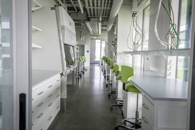 A lab sits empty in the SEC. Bright green chairs are the only spot of color among the clean, sleek, white and gray equipment.