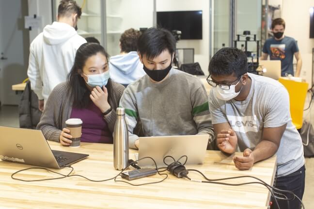 SEAS students Maegan Jong and Kevin Huang work with teaching fellow Ninad Jadhav