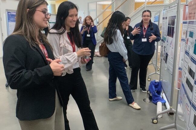 Graduate students looking at research posters