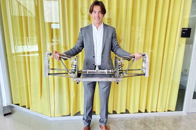 Harvard SEAS student Jack Meyer holding up a formula racecar steering system