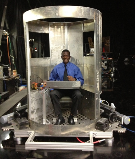 Tunde Demuren sits in the concept vehicle he and his teammates built during a NASA internship