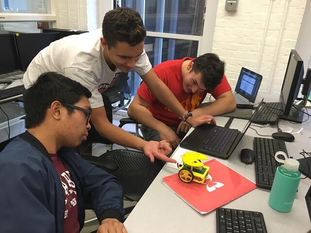 Malate and fellow members of the Harvard Undergraduate Robotics Club work on the PAC-MAN robot they built for an annual competition.