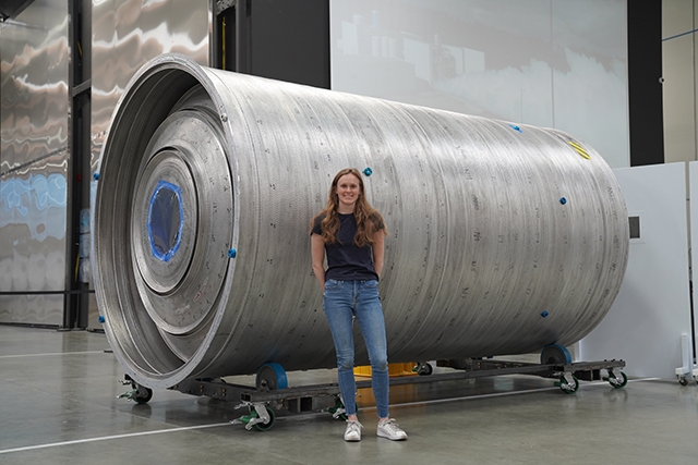 Annie Doris stands in front of a rocket component