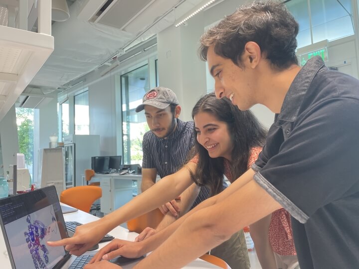 Harvard iGEM team members look at a simulation of their design