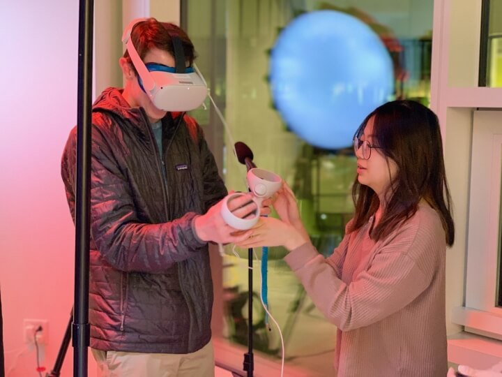 Alina Yu helps an attendee with his virtual reality headset
