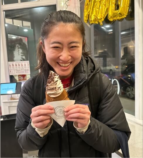 Image of Amberly Xie, a student fellow, smiling and holding an ice cream cone