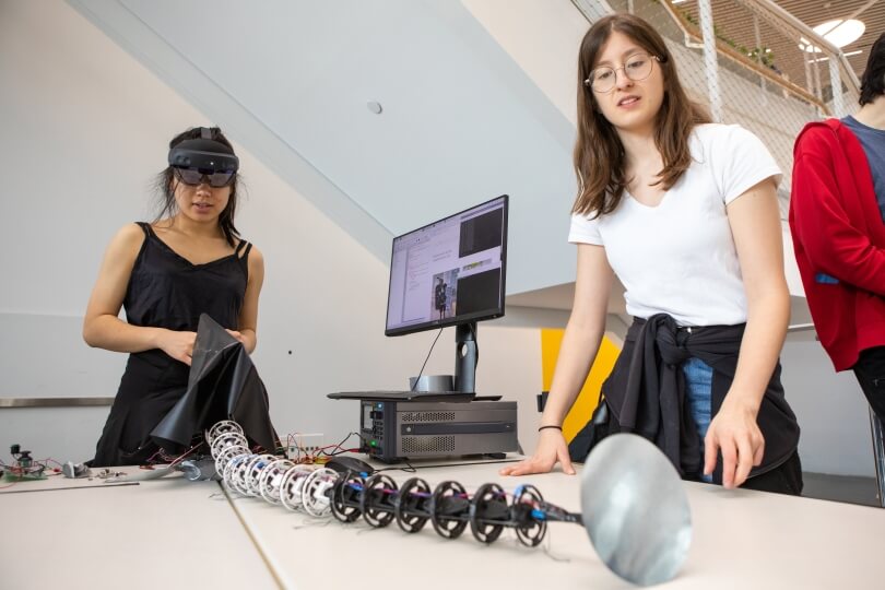 LimbX co-creator Alice Cai, left, maneuvers her robotic tentacle arm as co-creator Aida Baradari watches