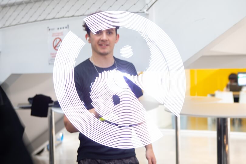 Steffan Jones projects a yin-yang symbol using a rotating drill and LED lights at the SEAS Design and Project Fair