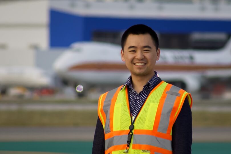 Photo of Raymond Wang, A.B. '20, in front of airplane