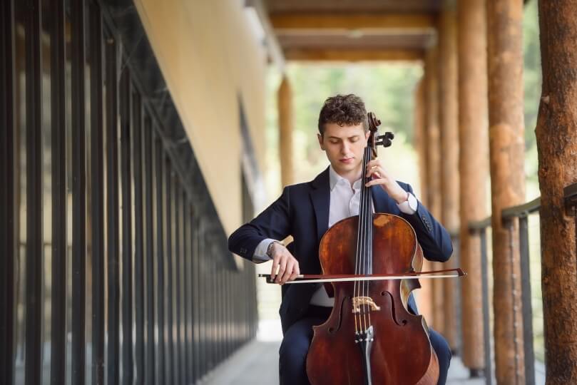 Ethan Cobb, A.B. '22, sitting with his cello