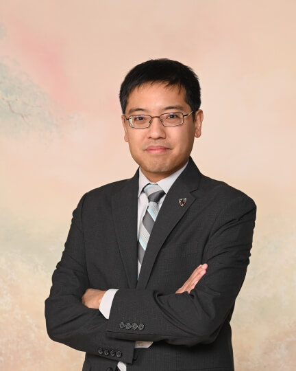 Photo of SEAS alum Eugene Beh, A.B./A.M. ‘09, wearing a grey suit and striped tie