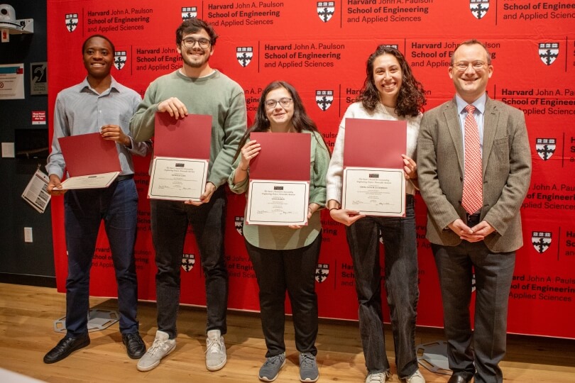 A group of Harvard SEAS seniors with Dean David Parkes, holding awards for honorable mention for outstanding engineering projects