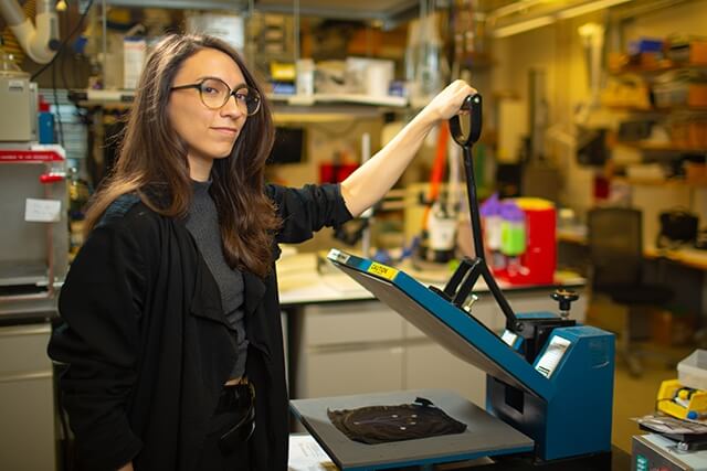 Harvard SEAS alum Vanessa Sanchez holding a press in a lab