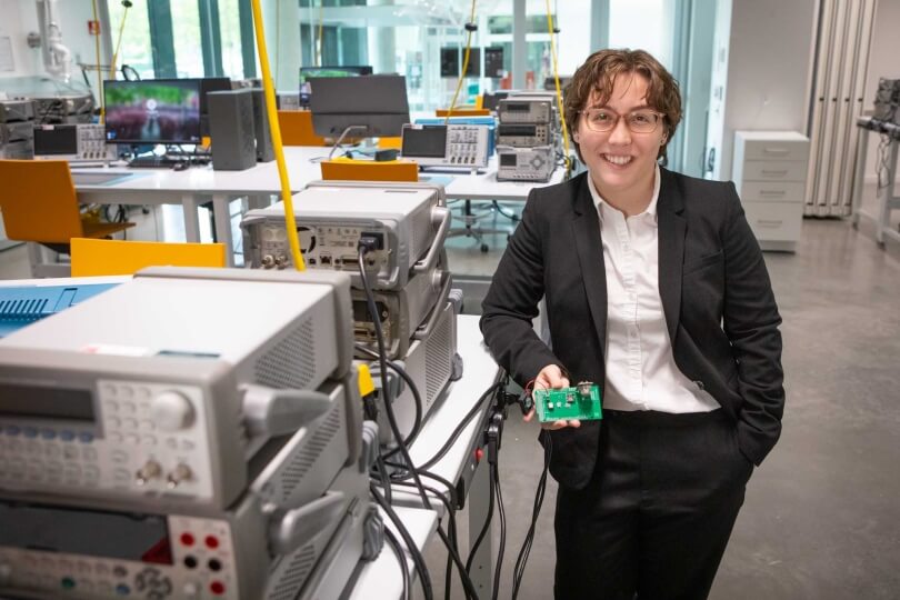 Harvard SEAS student Bella Pignataro holding an electronic circuit board