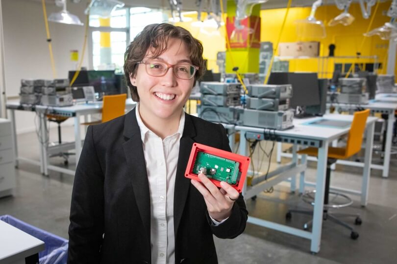Harvard SEAS student Bella Pignataro holding an electronic circuit board