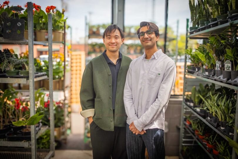 Harvard SEAS GSD students Akhil Dayal and Darren Chin in front of rows of potted plants