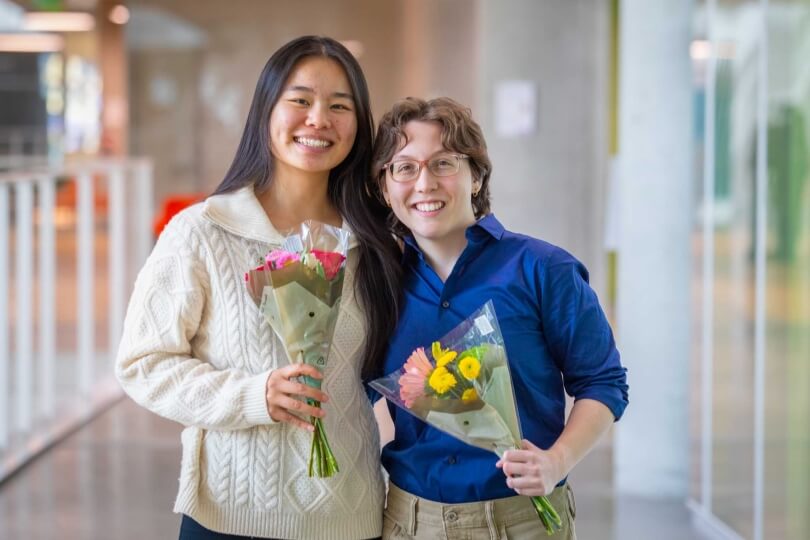Harvard SEAS students Zora Zheng and Bella Pignataro holding bouquets of flowers