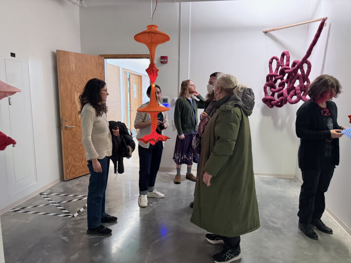 A crowd of people at an installation in the Harvard ArtLab