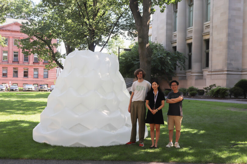 Researchers standing next to multistable inflatable cone