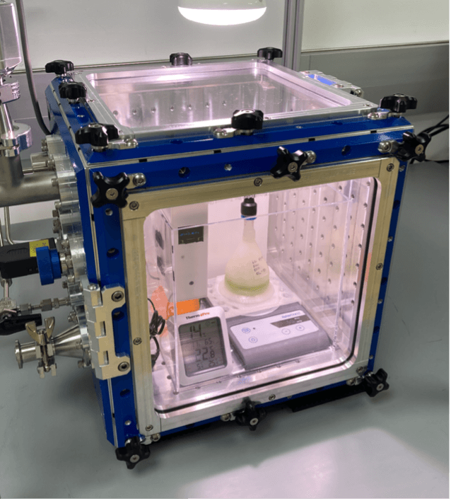 Lab chamber enclosing bioplastic habitat with algae growth