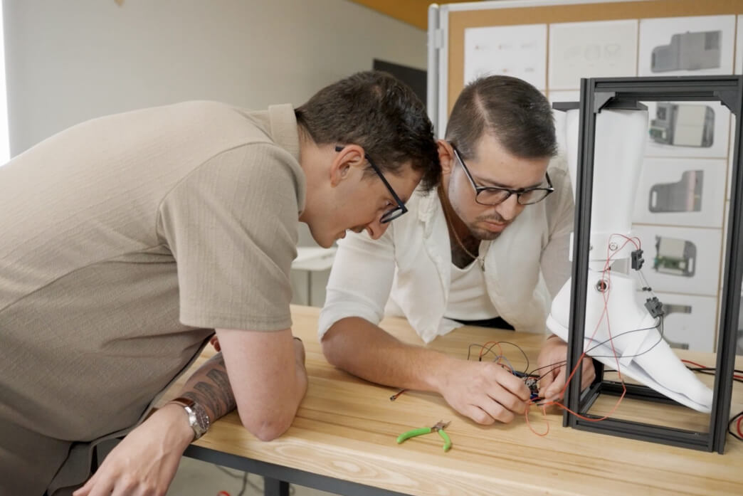 Harvard SEAS alums Viktor Bokisch and Bradley Wagman working on a robotic sock