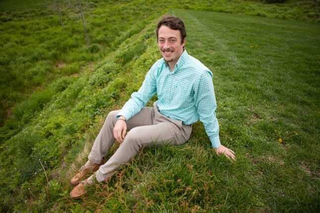 Billy Beauregard, S.B. '23 in environmental science and engineering, sitting on grass