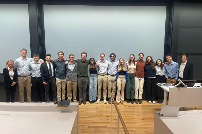 Harvard students standing in front of a projection screen