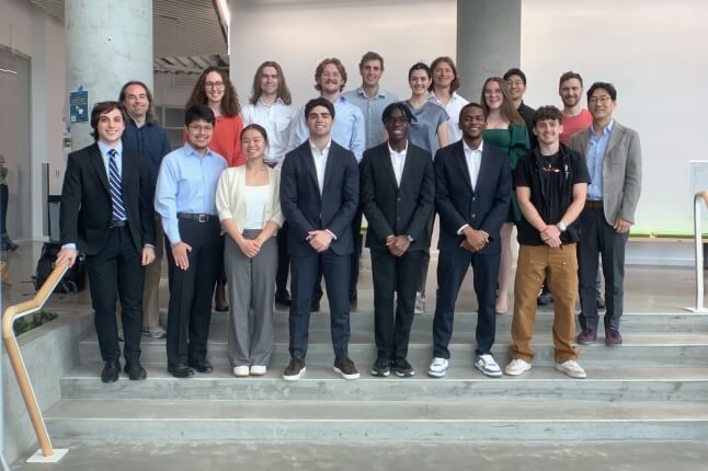 A group of Harvard SEAS students and professors standing on steps in the Science and Engineering Complex