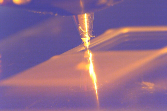 close-up of 3D printer nozzle writing square spirals