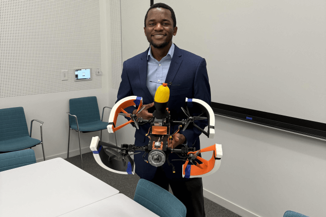 Harvard SEAS student Michael Awah holding a propellered vehicle