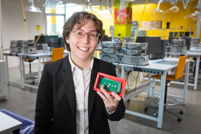 Harvard SEAS student Bella Pignataro holding an electronic circuit board
