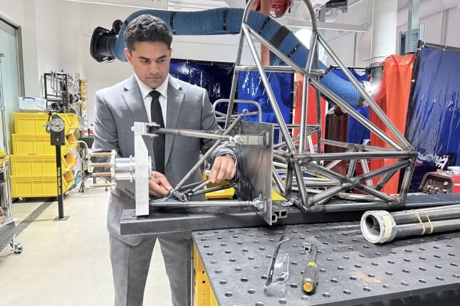 Harvard SEAS student Rayhaan Saaim attaching an automotive suspension system to a formula racecar chassis