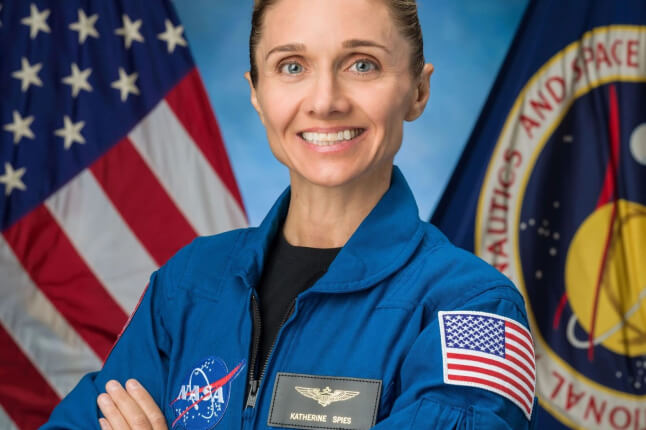 Harvard SEAS GSD alum Katherine Spies in her NASA uniform in front of an American Flag
