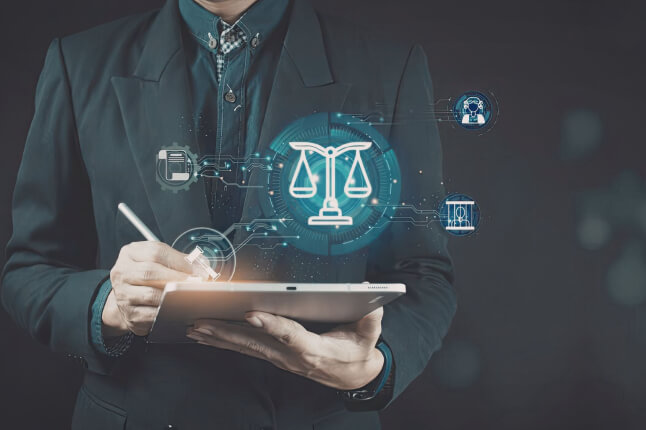  Alt text:  Person in a dark suit holding a digital tablet with a stylus, overlaid with glowing blue icons representing law and technology, including a central scale of justice, a gavel, and abstract AI and data symbols, suggesting the intersection of artificial intelligence and legal decision‑making