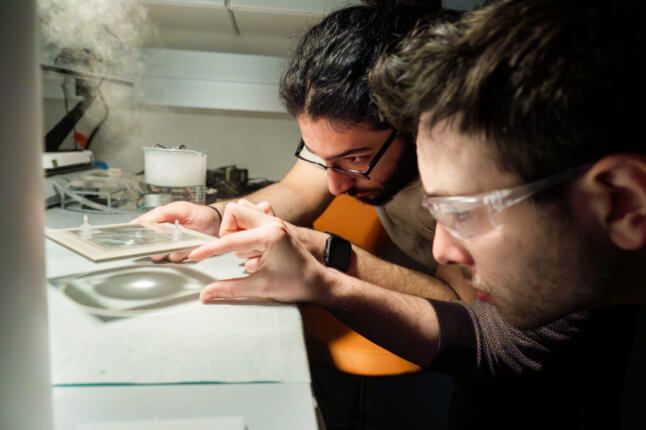 researchers examining heat harvesting experiment in the lab