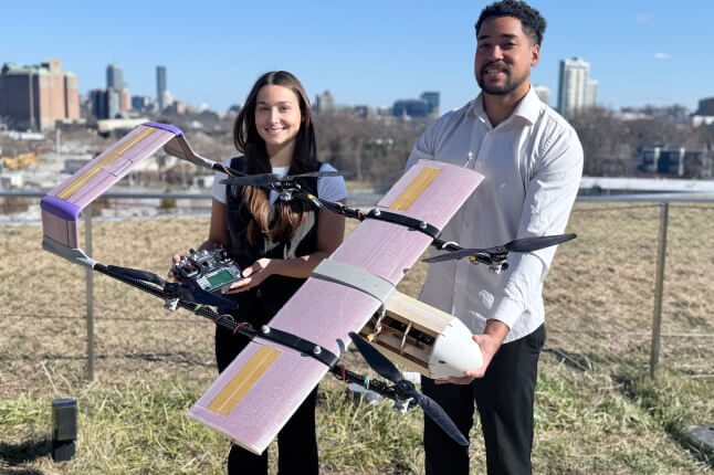 Harvard SEAS Kuma McCraw and Mikaya Parente holding a fixed-wing drone