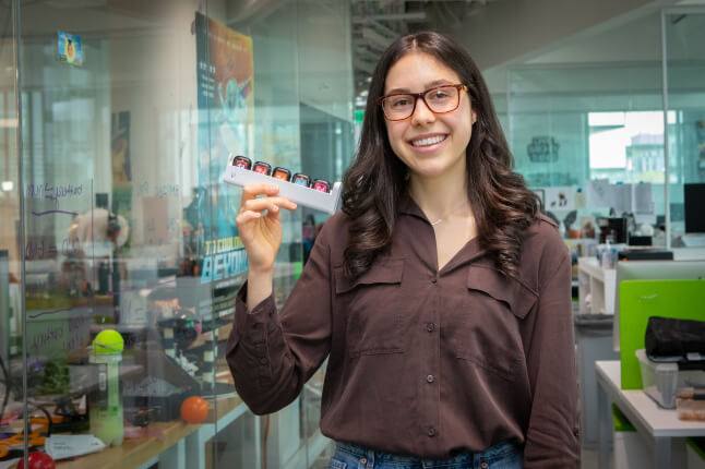 Harvard SEAS student Alissia Di Maria holding a tray of smart watches