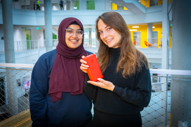 Harvard SEAS students Wafiqah Zubair and Madison Gates holding a red breathalyzer