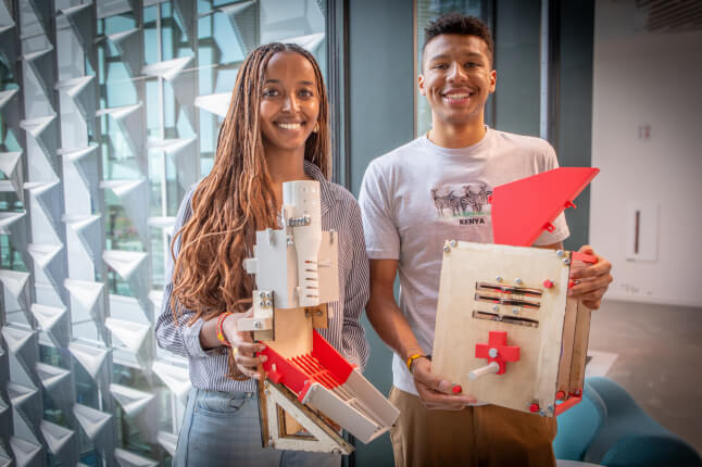 Harvard SEAS students Kulani Temesgen and Ayande Joseph holding devises for shelling maize