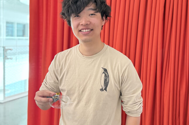 Harvard SEAS student Jerry Li holding a small electronic device
